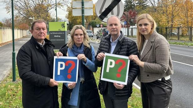 Vier Menschen vor einer Ortstafel