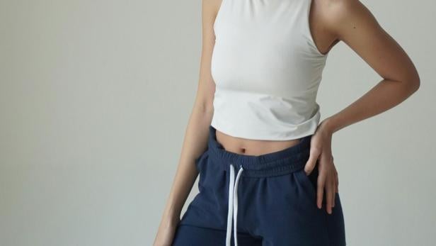 Frau mit weißem Tank-Top und dunkelblauer Jogginghose