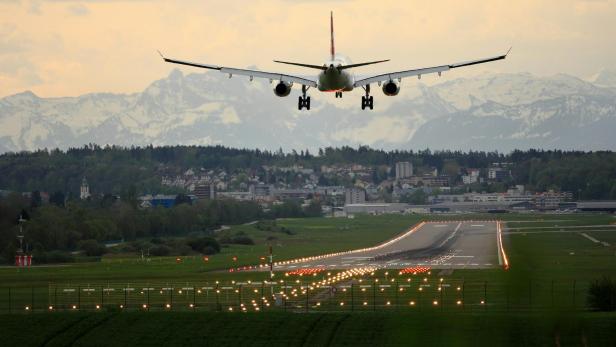 Ein Flugzeug bei der Landung, dahinter eine Bergkette