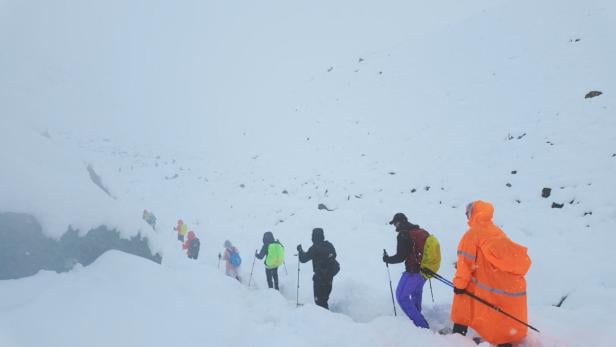A screen capture from video shows trekkers leaving their campsite, as unusually heavy snow and rainfall pummeled the Himalayas, in the Tibet Region