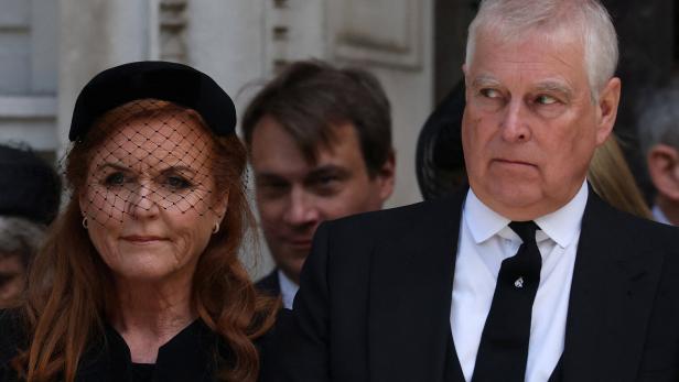 Sarah Ferguson und Prinz Andrew, beide in dunkler Kleidung, blicken ernst zur Seite.