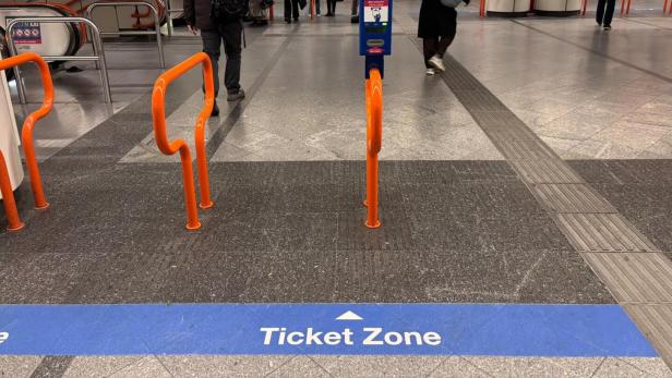 In einer U-Bahn-Station weist eine blaue Markierung auf eine Ticketzone hin.