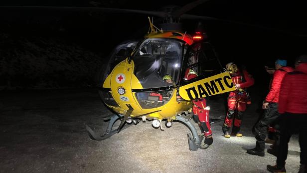 Bergrettung Werfen: Ein gelber ÖAMTC Hubschrauber im Dunkeln mit Einsatzkräften in rot gekleidet
