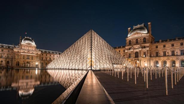 Typische Louvre-Pyramide in Paris bei Nacht