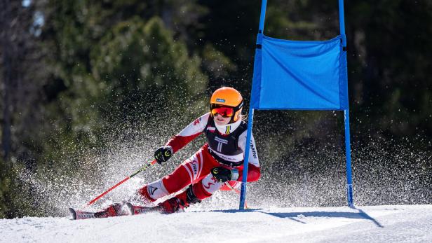 Eine junge Wiener Skirennläuferin fährt um ein blaues Riesentorlauf-Tor.