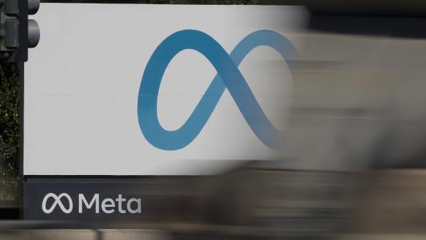 Das Meta-Logo mit einer blauen Unendlichkeitsform und dem Schriftzug „Meta“ ist auf einer weißen Tafel zu sehen.