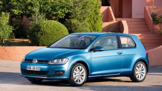 Ein blauer VW Golf steht vor einem Wohnhaus.