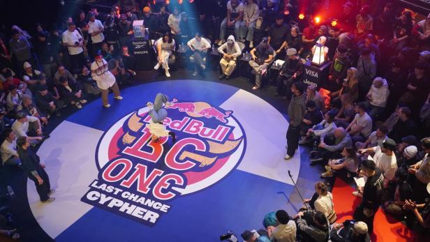 Breakdancerin auf dem Dancefloor, rundherum Publikum