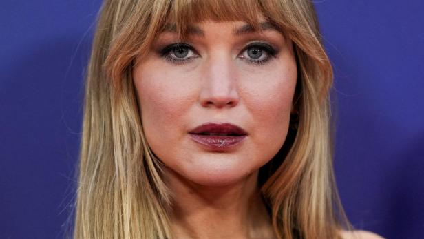 Jennifer Lawrence mit blonden Haaren und Pony trägt ein goldenes Halsband.