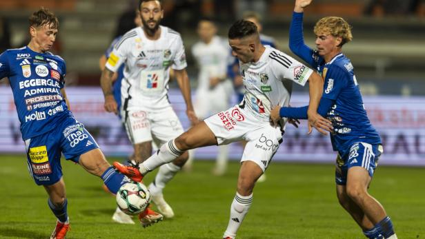 Ein WAC-Spieler ist von zwei Hartbergern umringt.