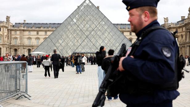 FILE PHOTO: A French CRS riot police officer patrols near the glass Pyramid of the Louvre Museum