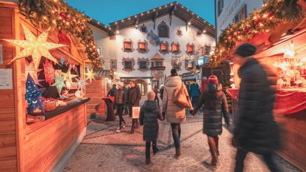 Beleuchtete Stände eines Weihnachtsmarktes in der Kitzbüheler Innenstadt.