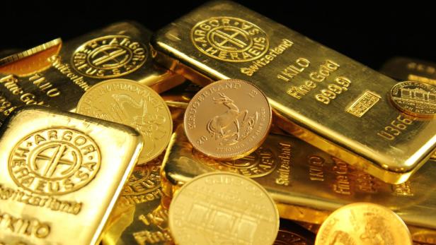 Goldbarren und Münzen auf einem Haufe