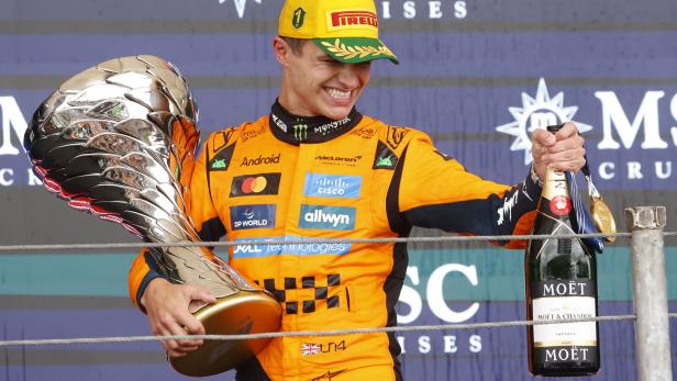 Lando Norris mit Pokal und Champagner