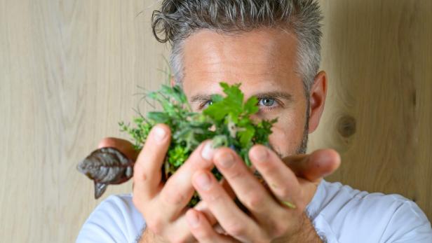 Mann hält sich Kräuter vors Gesicht