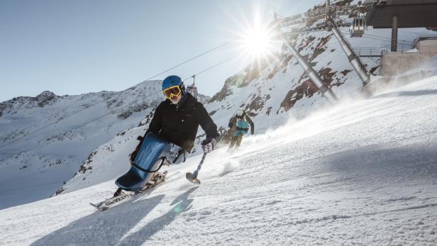 Monoskifahrer fährt eine Piste hinunter