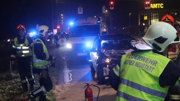 Feuewehrleute im Vordergrund, dahinter ein Auto und Einsatzfahrzeuge