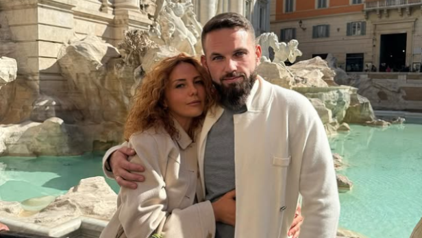 Krypto-Millionär Roman Novak und seine Frau Anna posieren vor einem Brunnen