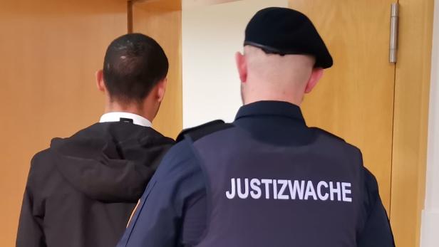 Angeklagter wird von Justizwachebeamten in den Verhandlungssaal geführt.