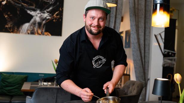 Ein Mann mit Cappie richtet Essen an. // Linko´s Bachstüberl überzeugt in Purkersdorf mit regionaler Küche, kreativen Menüs und nachhaltigem Gasthauskonzept.