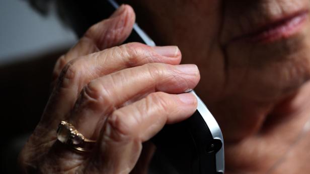 Ältere Frau hält ein Handy ans Ohr