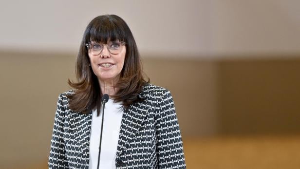 Martha Schultz mit Brille und gemustertem Blazer spricht am Mikrofon.