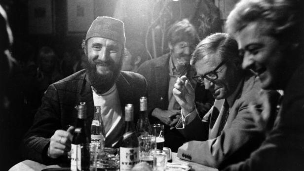 Männer sitzen an einem Tisch mit Getränken in einer Bar.
