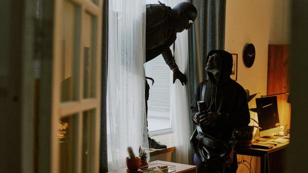 Zwei Personen begehen einen Dämmerungseinbruch