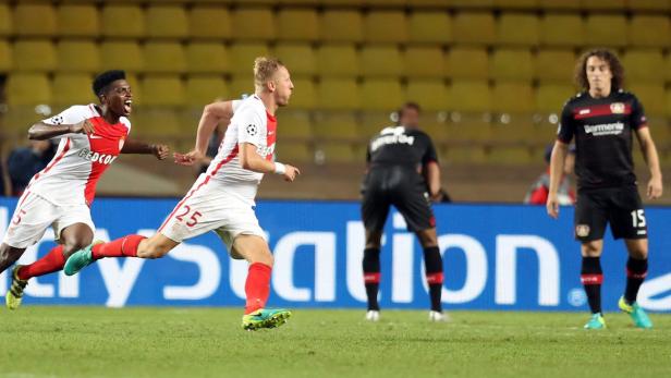 Zwei Fußballspieler von Monaco jubeln auf dem Spielfeld.