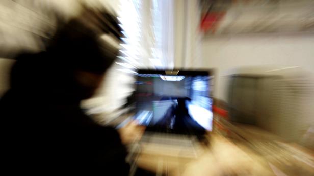 Eine Person spielt ein Computerspiel auf einem Laptop.