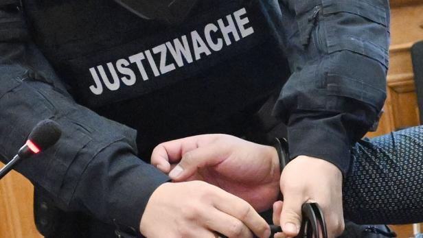 Justizwachebeamter legt Häftling Handschellen an