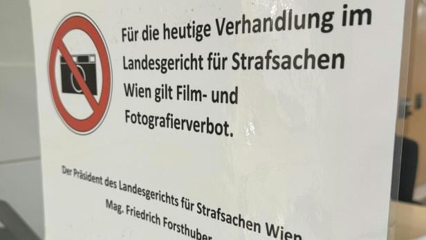 Hinweisschild mit rotem Kamera-Verbotssymbol informiert über Film- und Fotografierverbot im Landesgericht für Strafsachen Wien.