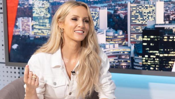 Frau sitzend mit blonden Haaren und weißem Gewand