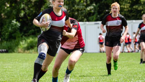 Eine österreichische Rugbyspielerin trägt den Ball.