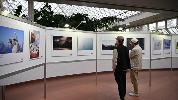 Zwei Männer begutachten Fotografien im Rahmen der Messe Photo + Adventure an.
