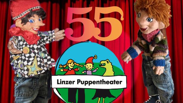 Zwei Kasperlpuppen vor einem Schild