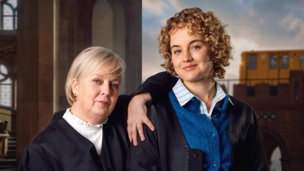 Eine Frau stützt ihren Arm auf die Schulter der anderen