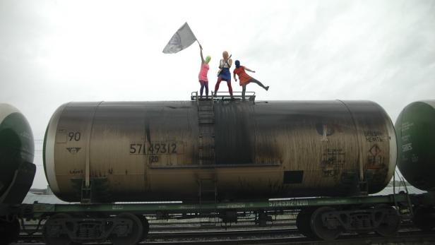 Members of the Pussy Riot punk band perform on an oil transport wagon in this undated Russy Riot Group handout photograph obtained by Reuters July 16, 2013. The band took aim at President Vladimir Putin and how he runs Russia&#039;s oil industry on Tuesday in its first video for almost a year. REUTERS/Pussy Riot Group/Handout via Reuters (RUSSIA - Tags: ENTERTAINMENT POLITICS TPX IMAGES OF THE DAY CIVIL UNREST ENERGY) ATTENTION EDITORS - THIS IMAGE WAS PROVIDED BY A THIRD PARTY. FOR EDITORIAL USE ONLY. NOT FOR SALE FOR MARKETING OR ADVERTISING CAMPAIGNS. NO SALES. NO ARCHIVES. THIS PICTURE IS DISTRIBUTED EXACTLY AS RECEIVED BY REUTERS, AS A SERVICE TO CLIENTS