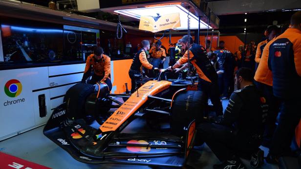 Mechaniker arbeiten in der McLaren-Box an dem Auto.
