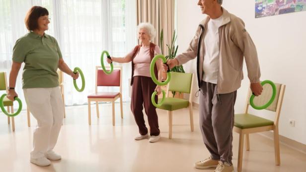 Senioren turnen in einem hellen Raum eines Seniorenzentrums.