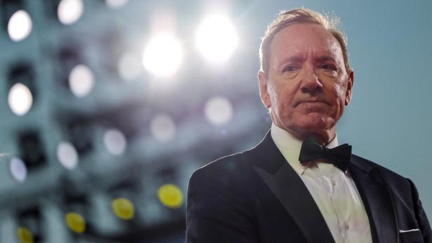 Kevin Spacey mit Fliege und dunklem Anzug vor hellem, unscharfem Hintergrund.