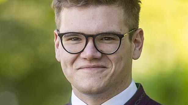 Junger Mann mit Gilet, Krawatte und Brille