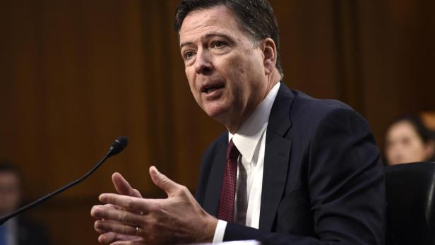James Comey gestikuliert während einer Anhörung vor einem Mikrofon.