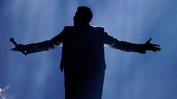 Ein Sänger auf einer Bühne von hinten.