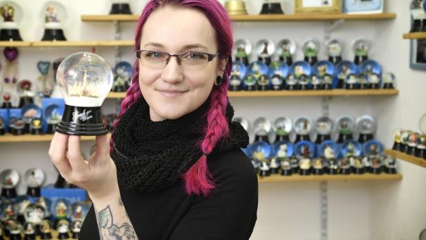 Junge Frau mit Schneekugel und roten Haaren