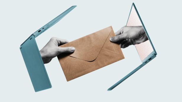 Zwei geöffnete Laptops, zwischen denen zwei Hände einen braunen Briefumschlag übergeben.