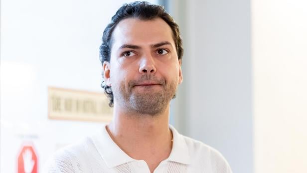 Jimi Blue Ochsenknecht mit dunklen Haaren und Bart trägt ein weißes Hemd und schaut zur Seite.