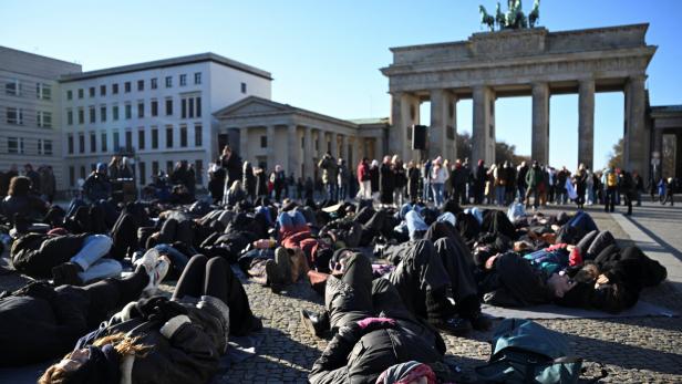 Frauen liegen auf den Boden vor dem Brandenburger Tor in Berlin