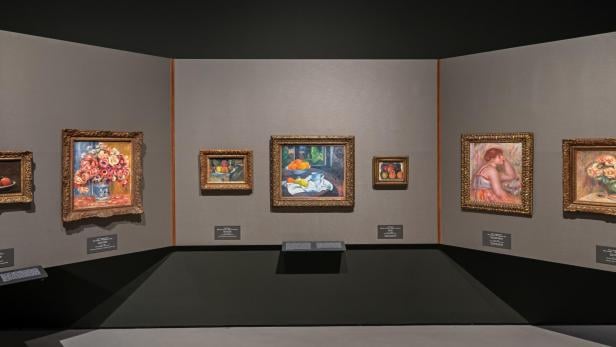 Sechs gerahmte Gemälde an einer Museumsmauer, darunter Stillleben mit Blumen und Früchten sowie ein Aktbild, alle in goldfarbenen Rahmen.