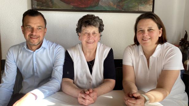 Zwei Frauen und ein Mann sitzen an einem Tisch